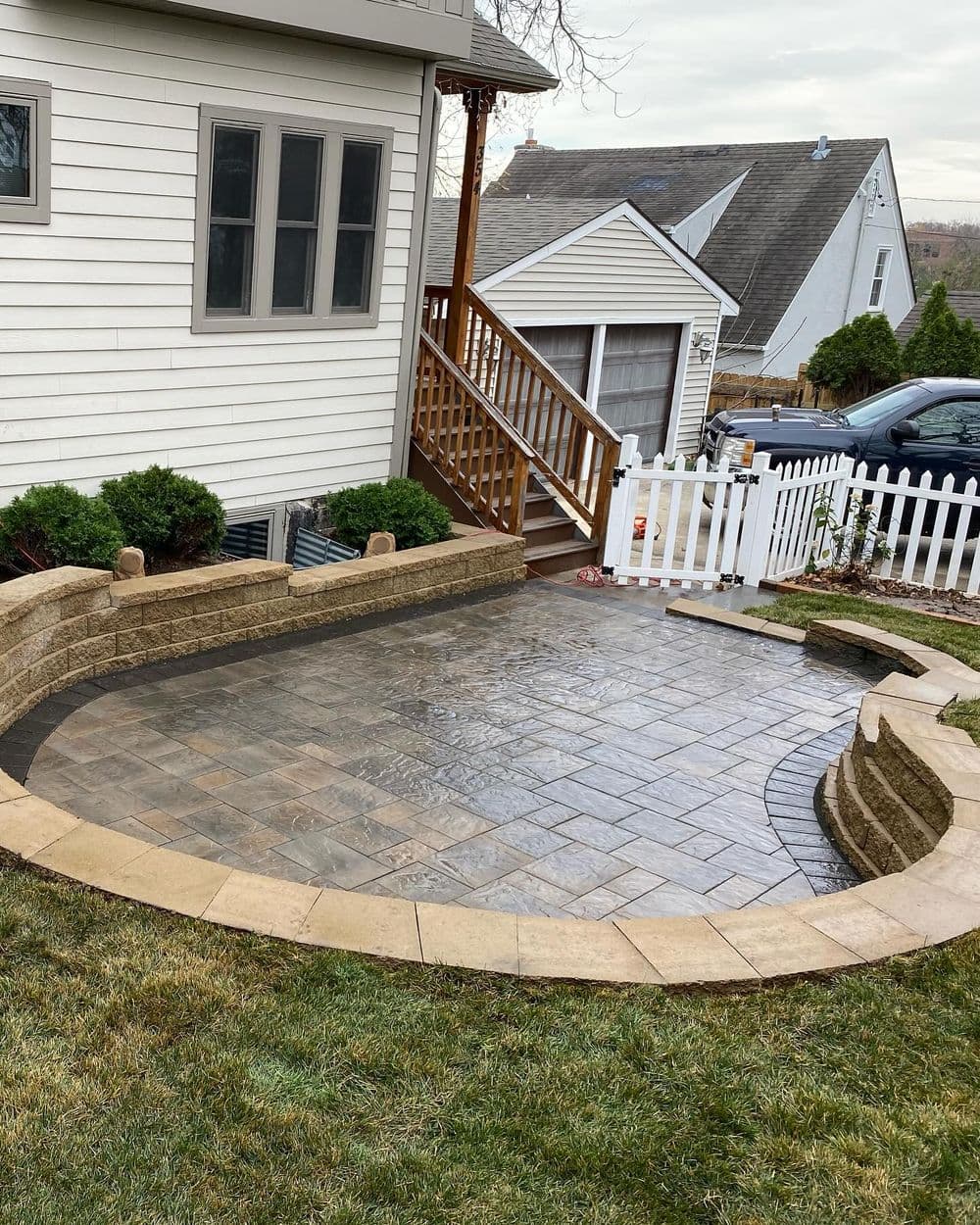 Patio renovation featuring stone paver design and landscaping near a residential home.